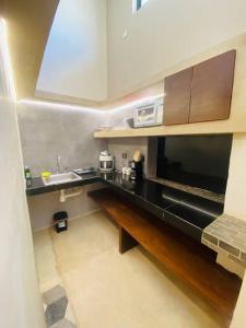 a kitchen with a black counter and a microwave at Ko'ox 52 in Mérida