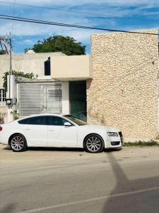 a white car parked in front of a building at Ko'ox 52 in Mérida +15 photos