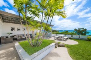 a backyard with palm trees and a patio at A Point of View in Airlie Beach