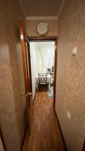 un pasillo con un reloj en la pared y una mesa en 2х комнатная квартира на Толе би, en Taraz 9 fotos más