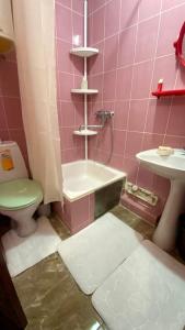 a pink bathroom with a toilet and a sink at 2х комнатная квартира на Толе би in Taraz