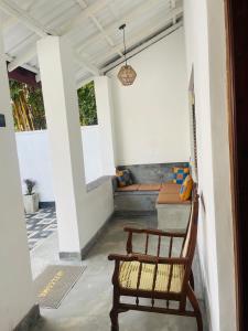 a porch with a bench and a table and chairs at Villa 754 in Dickwella