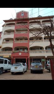 a large building with cars parked in front of it at THE DESERT ROSE HOTEL VOI in Voi