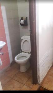 a bathroom with a white toilet and a sink at THE DESERT ROSE HOTEL VOI in Voi