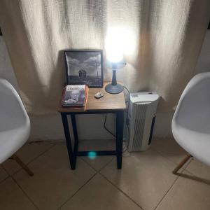 une table avec une lampe et une photo sur celle-ci dans l'établissement Hostel La Escondida 094625953, à Parque del Plata
