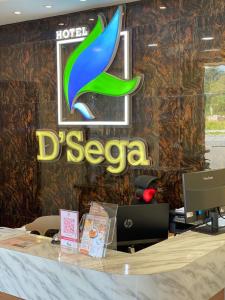MacangにあるD SEGA HOTELの壁にデックスザの看板が付いたフロントデスク