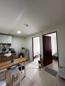 a kitchen with a table and chairs in a room at Cozy 2-BR in UDH, Manila in Manila