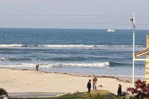 een groep mensen die op een strand bij de oceaan staan bij Ótimo apartamento com ampla sacada e vista pro mar in São Francisco do Sul