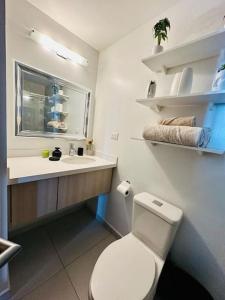 y baño con aseo blanco y lavamanos. en Luxury 1BR Apartment in Astria 706, en Tegucigalpa
