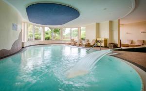 a swimming pool with a fountain in a hotel room at Landhotel Heimathenhof in Heimbuchenthal