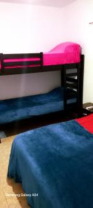 two bunk beds in a room with a blue bed at Alquiler de departamentos por dia Novos Apart Catamarca in San Fernando del Valle de Catamarca