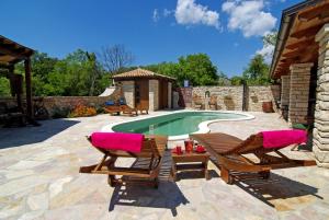 een zwembad met 2 ligstoelen en een zwembad bij Villa Milica - Istrian ecohouse in Barban
