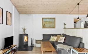 sala de estar con sofá y chimenea en Cozy Cottage In Scenic Surroundings, en Melby