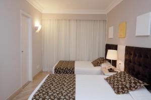 a hotel room with two beds and a lamp at Bristol International Guarulhos in Guarulhos