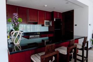 a kitchen with red cabinets and a black counter top at Beach resort Bali style villa 24 in Koh Samui 