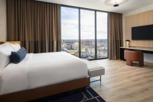 una camera d'albergo con un letto e una grande finestra di Cascade Hotel, Kansas City, a Tribute Portfolio Hotel a Kansas City