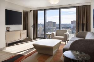 ein Wohnzimmer mit Couch und großem Fenster in der Unterkunft Cascade Hotel, Kansas City, a Tribute Portfolio Hotel in Kansas City