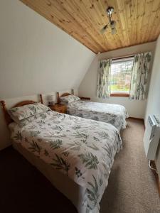 1 dormitorio con 2 camas y ventana en A haven of peace and tranquility, en Aultbea