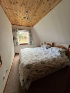 1 dormitorio con 1 cama con techo de madera en A haven of peace and tranquility, en Aultbea