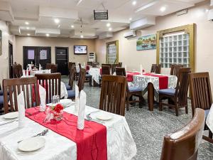 un restaurante con mesas y sillas con manteles rojos y blancos en Parkview Astoria Hotel en Lagos