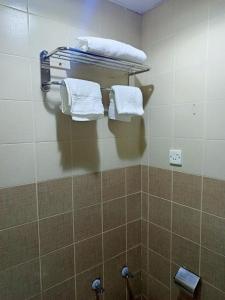 a bathroom with white towels hanging on a wall at شقق الملتقي in Al Nairyah