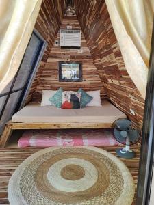 a room with a bed in a wooden house at Arzel Resort in Mangatarem