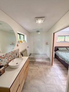 a bathroom with a sink and a bed and a mirror at Heart of Witchcliffe in Margaret River Town