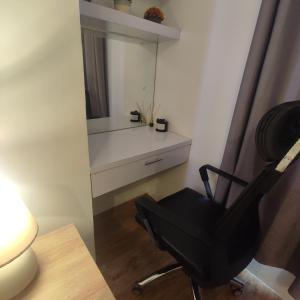 une chaise noire dans une chambre avec un miroir dans l'établissement Luxury spacious 2BR in Salcedo Village, à Manille