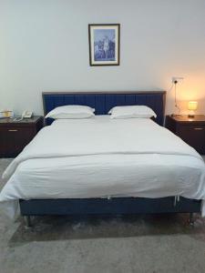 a large bed in a room with two nightstands at شقق الملتقي in Al Nairyah