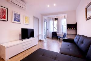 ein Wohnzimmer mit einem Sofa und einem Flachbild-TV in der Unterkunft Apartment Park&Beach Deluxe in Barcelona