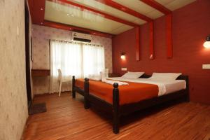 um quarto com uma cama grande e paredes vermelhas em Harmony Houseboats em Alappuzha