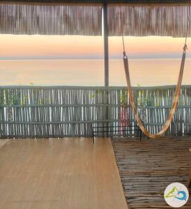 a room with a wooden floor and a swing at Kubo house by the water in ELYU, Ba-ey Ad Shanom in San Fernando