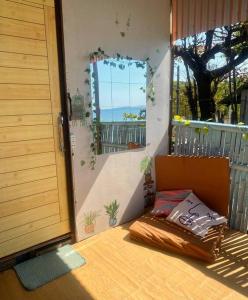 - un lit installé sur une terrasse couverte avec une fenêtre dans l'établissement Kubo house by the water in ELYU, Ba-ey Ad Shanom, à San Fernando