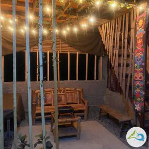 une chambre avec une tente dotée de bancs et de lumières dans l'établissement Kubo house by the water in ELYU, Ba-ey Ad Shanom, à San Fernando