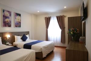 um quarto de hotel com duas camas e uma janela em DẠ LAN HOTEL em Da Lat