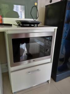 a microwave in a cabinet with a television on it at ดุสิตแกรนด์ คอนโดวิว 805 in Jomtien Beach