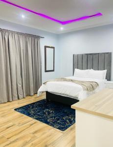een slaapkamer met een bed en een paars licht bij Airport Imperial Guest House in Kempton Park