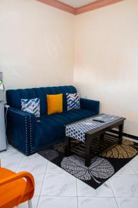 Sofá azul en la sala de estar con mesa de centro en Beach Box Dimash Apartments, en Mombasa