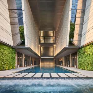 uma piscina no meio de um edifício em Rosewood Bangkok em Bangkok