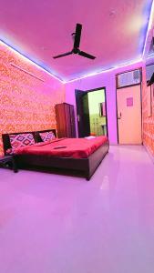 a pink room with a bed with a ceiling fan at Hotel shayam in New Delhi