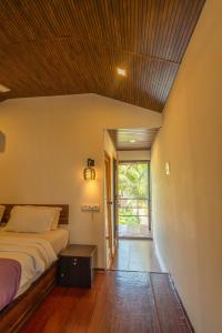 a bedroom with a bed and a large window at Agonda Serenity Resort in Agonda