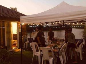 een groep mensen die aan een tafel onder een tent zitten bij บ้านกลางโดม Baan Klang Dome in Ban Huai Hai