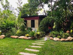 un jardín con un camino de piedra que conduce a una casa en บ้านกลางโดม Baan Klang Dome, 