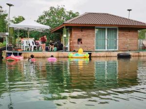 una casa en el agua con barcos en el agua en บ้านกลางโดม Baan Klang Dome, 