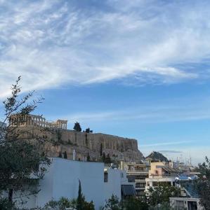 uma vista para uma cidade com uma montanha ao fundo em Arthome Acropolis View em Atenas