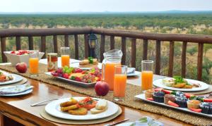 a table with plates of food and orange juice at Lucca Lodge in Musina