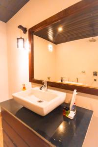 a bathroom with a sink and a large mirror at Agonda Serenity Resort in Agonda +36 photos