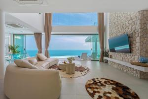 Villa The Wave 2 Residence في شاطئ لاماي: غرفة معيشة مع أريكة بيضاء ونافذة كبيرة