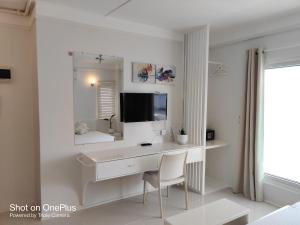 a white bathroom with a desk and a mirror at Mecasa Hotel in Boracay