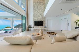 Elle comprend un salon doté d'un mobilier blanc et de grandes fenêtres. dans l'établissement Villa The Wave 2 Residence, à Lamai